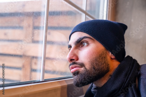 Arabic Muslim man looking from window feeling sad