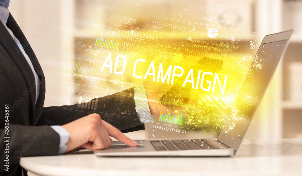 Closeup of businessman hands working on laptop with AD CAMPAIGN inscription, succesfull business concept