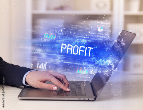 Closeup of businessman hands working on laptop with PROFIT inscription, succesfull business concept