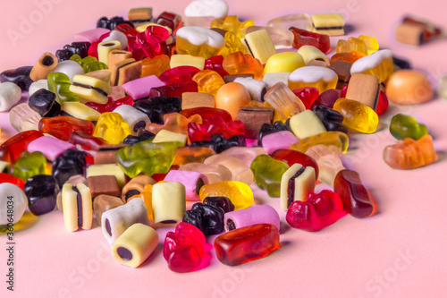 Colorful candy on pink background. Chewing sweets on light table. Top view, flat lay, copy space
