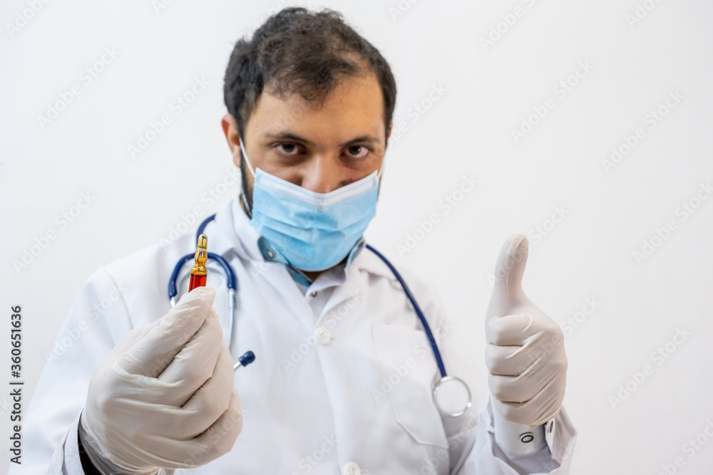 Arabic muslim doctor holding vaccine in his hand Arabic muslim doctor holding vaccine in his hand