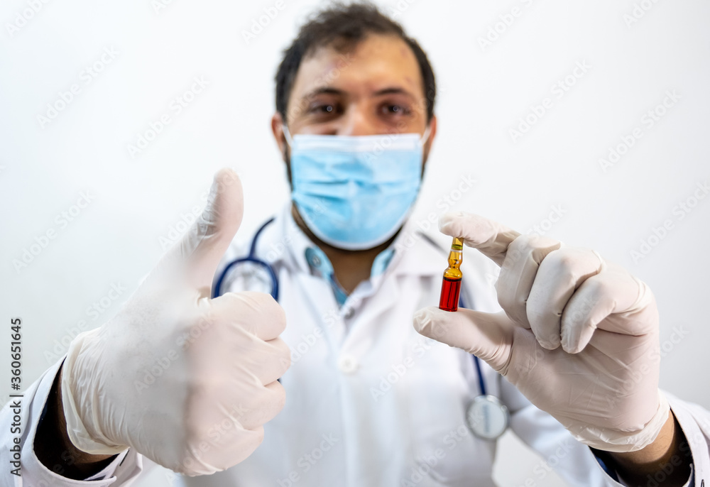 Arabic muslim doctor holding vaccine in his hand Arabic muslim doctor holding vaccine in his hand
