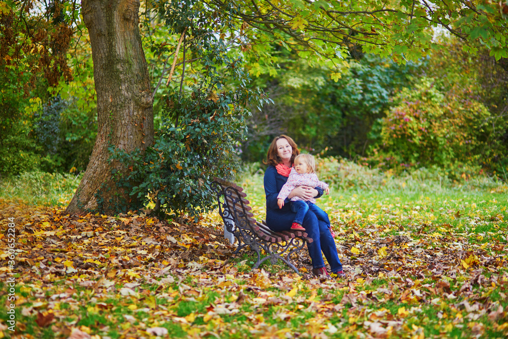 Happy smiling woman with toddler girl on fall day in park Happy smiling woman with toddler girl on fall day in park