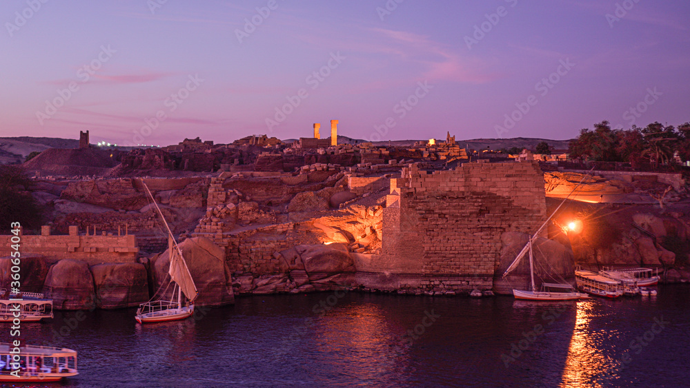 Nile river at sunset evening beautiful sky with ruin wall and lighting with felluca boat crusing