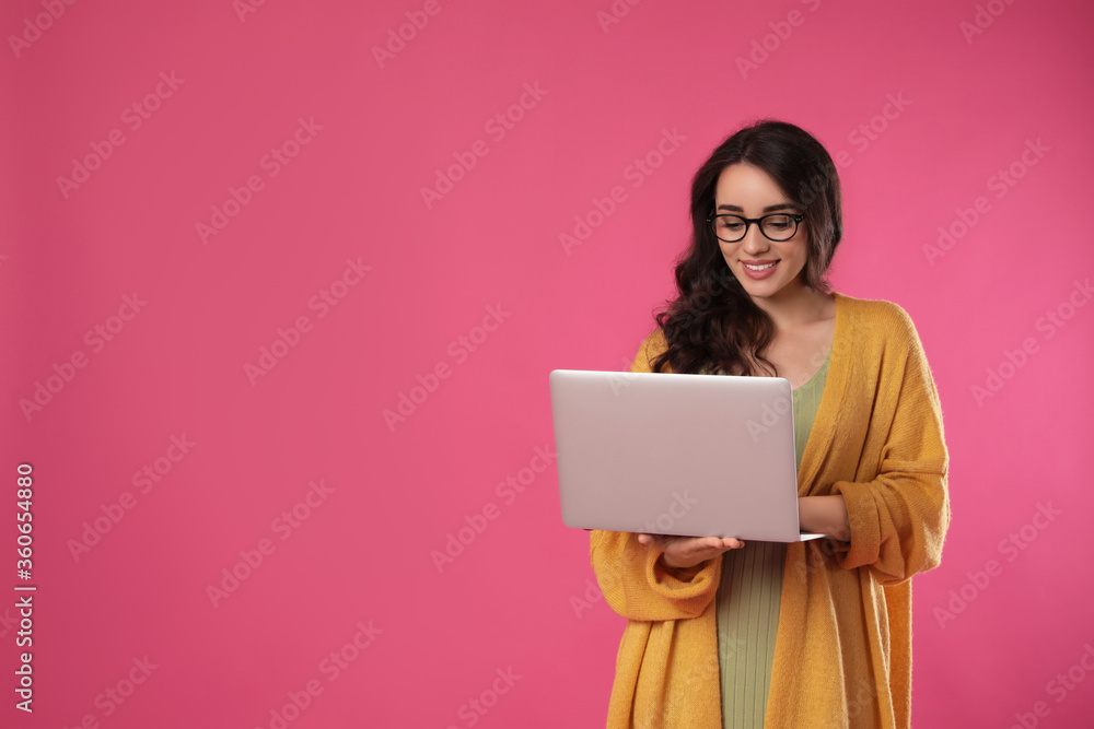 Young woman with laptop on pink background. Space for text Young woman with laptop on pink background. Space for text