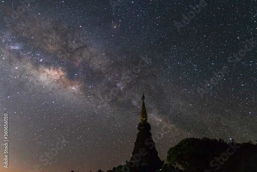 Milky way galaxy with stars on night sky ; silhouette of The Great Holy Relics Pagoda at Doi Inthanon Chiang Mai, Thailand.