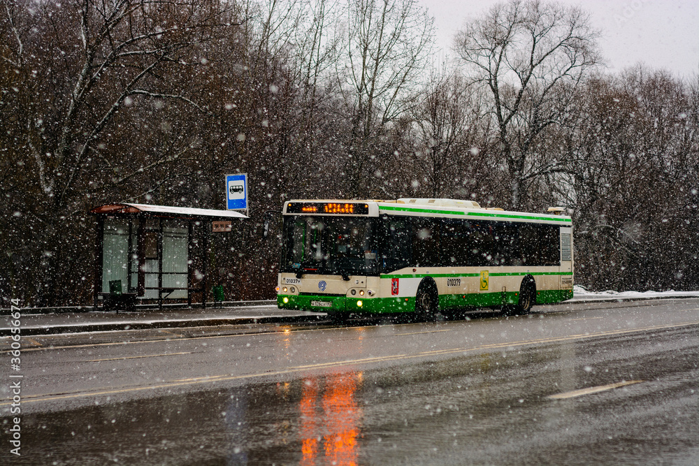 Fototapeta premium bus on the street while snowfall