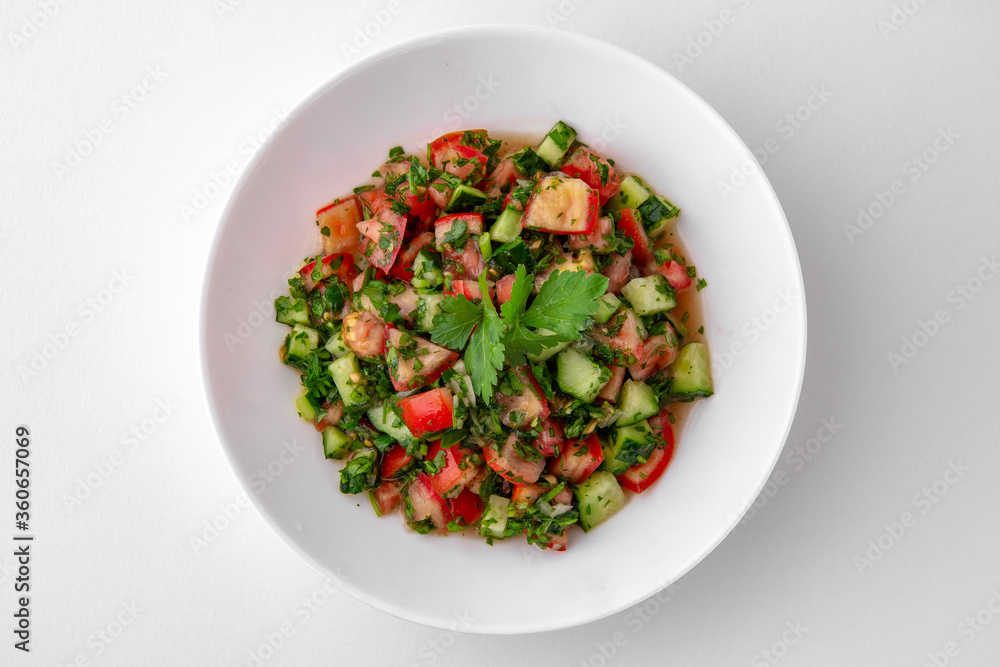 Salad of tomatoes, cucumber, sweet pepper and finely chopped greens with sauce top view. Dishes for delivery, online store. Isolated on a white background. Salad of tomatoes, cucumber, sweet pepper and finely chopped greens with sauce top view. Dishes for delivery, online store. Isolated on a white background.