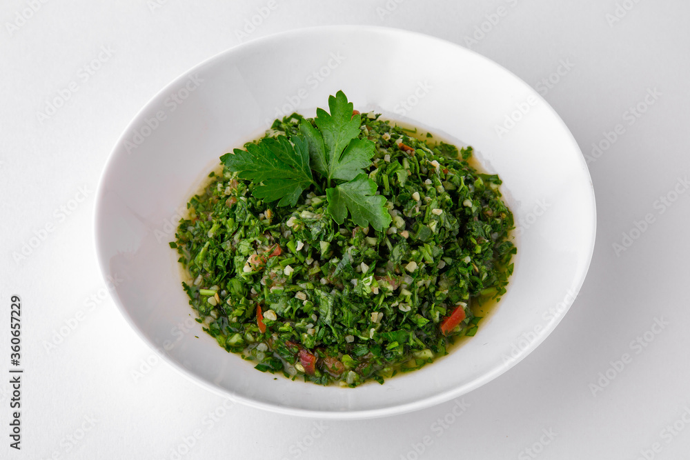 Salad of finely chopped herbs with sauce top view. Dishes for delivery, online store. Isolated on a white background. Salad of finely chopped herbs with sauce top view. Dishes for delivery, online store. Isolated on a white background.