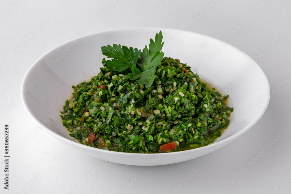 Salad of finely chopped herbs with sauce top view. Dishes for delivery, online store. Isolated on a white background. Salad of finely chopped herbs with sauce top view. Dishes for delivery, online store. Isolated on a white background.