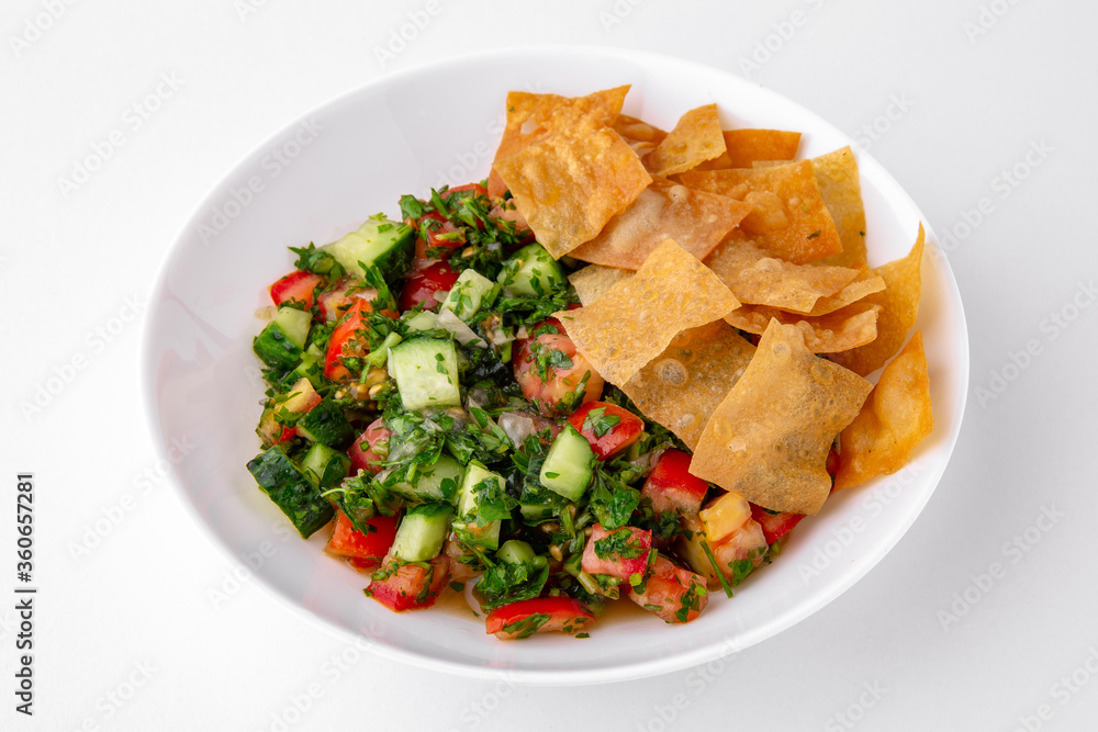 Salad of tomatoes, cucumber, sweet pepper and finely chopped herbs with sauce and chips top view. Dishes for delivery, online store. Isolated on a white background. Salad of tomatoes, cucumber, sweet pepper and finely chopped herbs with sauce and chips top view. Dishes for delivery, online store. Isolated on a white background.
