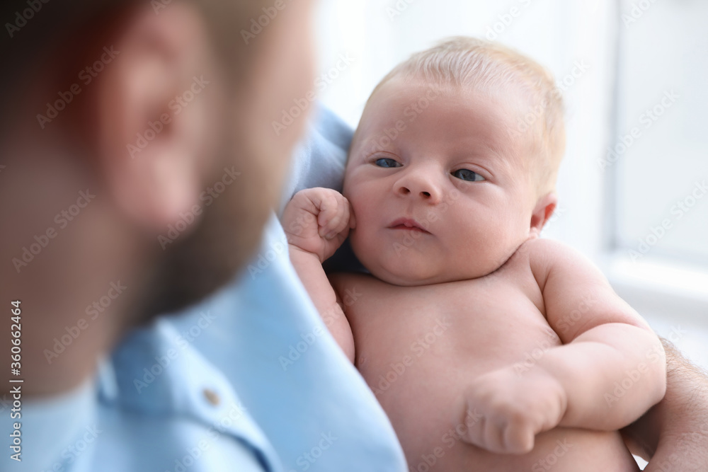 Father holding his cute newborn baby at home, closeup Father holding his cute newborn baby at home, closeup
