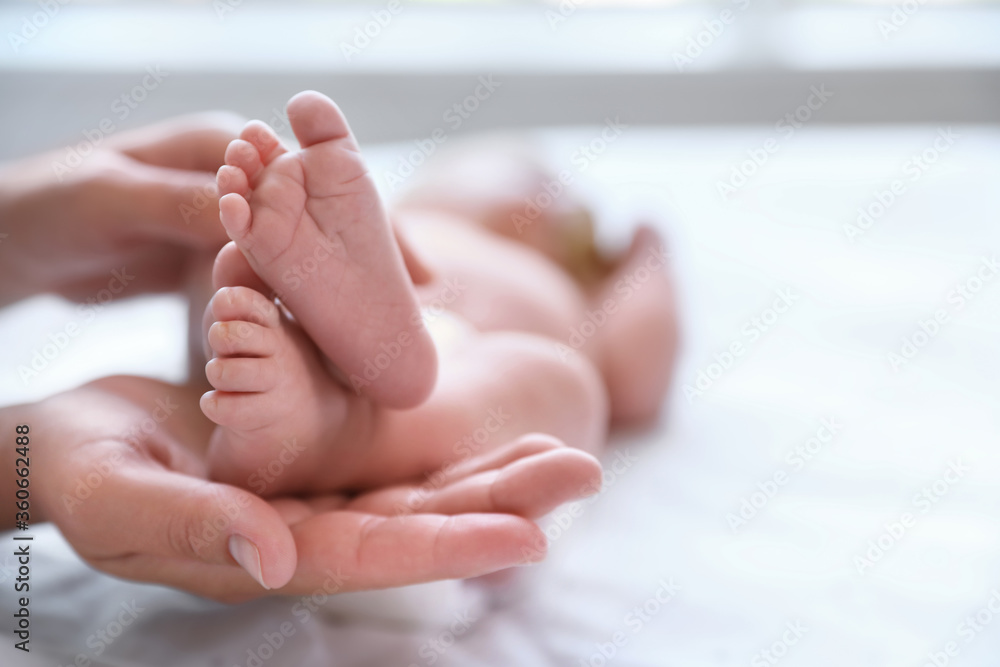 Mother and her newborn baby on bed, closeup. Space for text Mother and her newborn baby on bed, closeup. Space for text