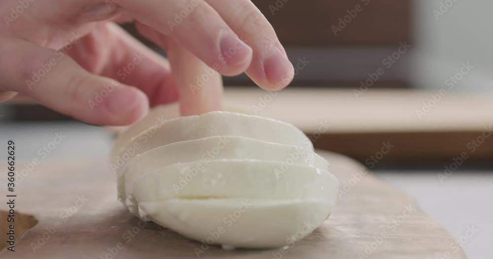 Slow motion dolly shot of man take mozzarella ball from olive wood board Slow motion dolly shot of man take mozzarella ball from olive wood board