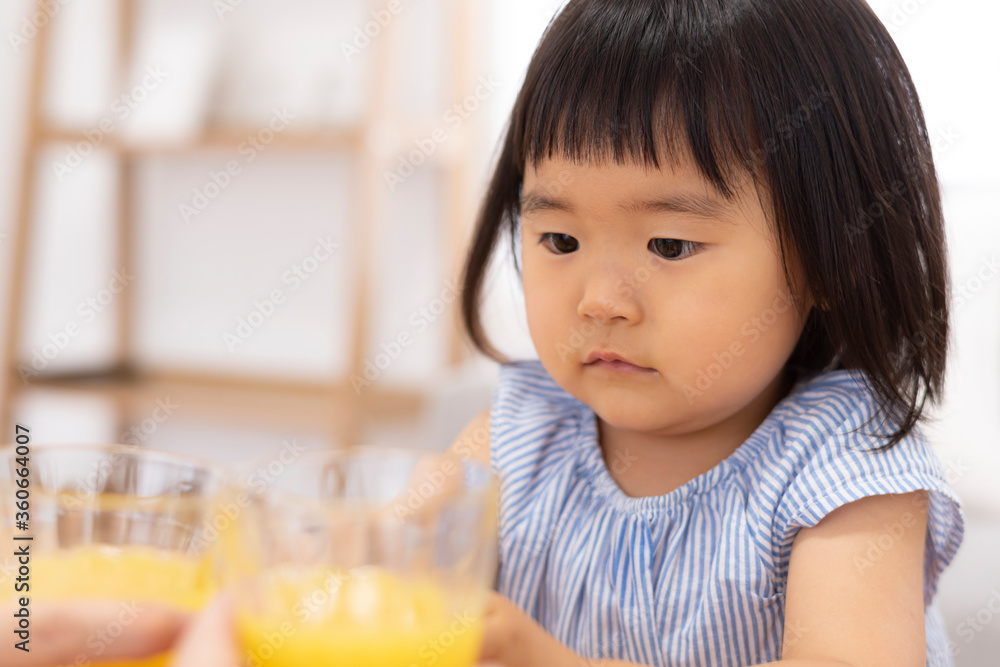 オレンジジュースで乾杯する子供