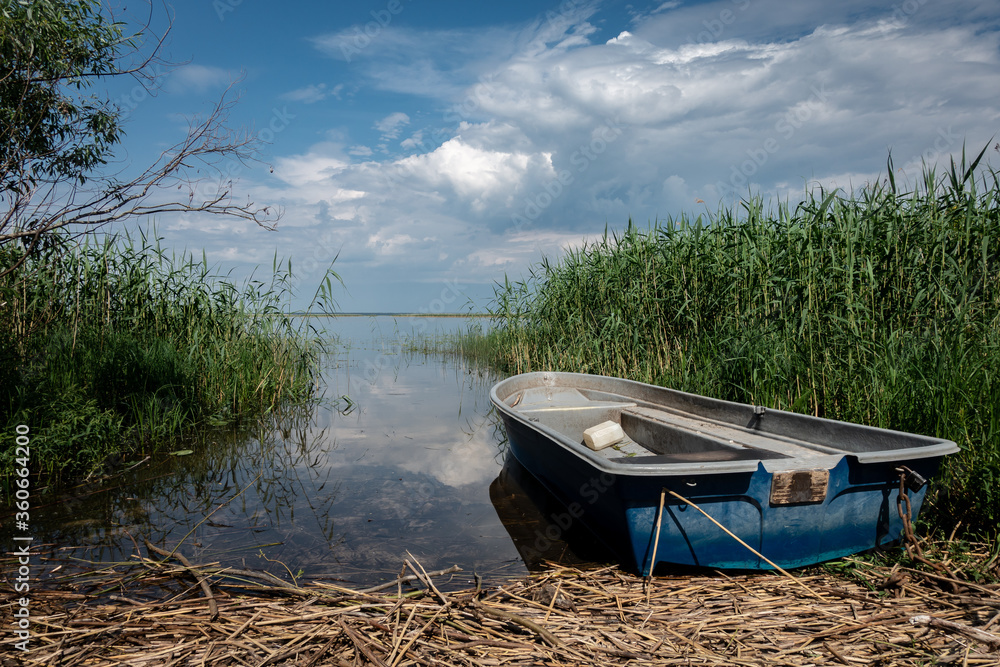 Obraz premium A lonely boat on the shores of the lake Lubana. Lubana Lake is the largest lake in Latvia.