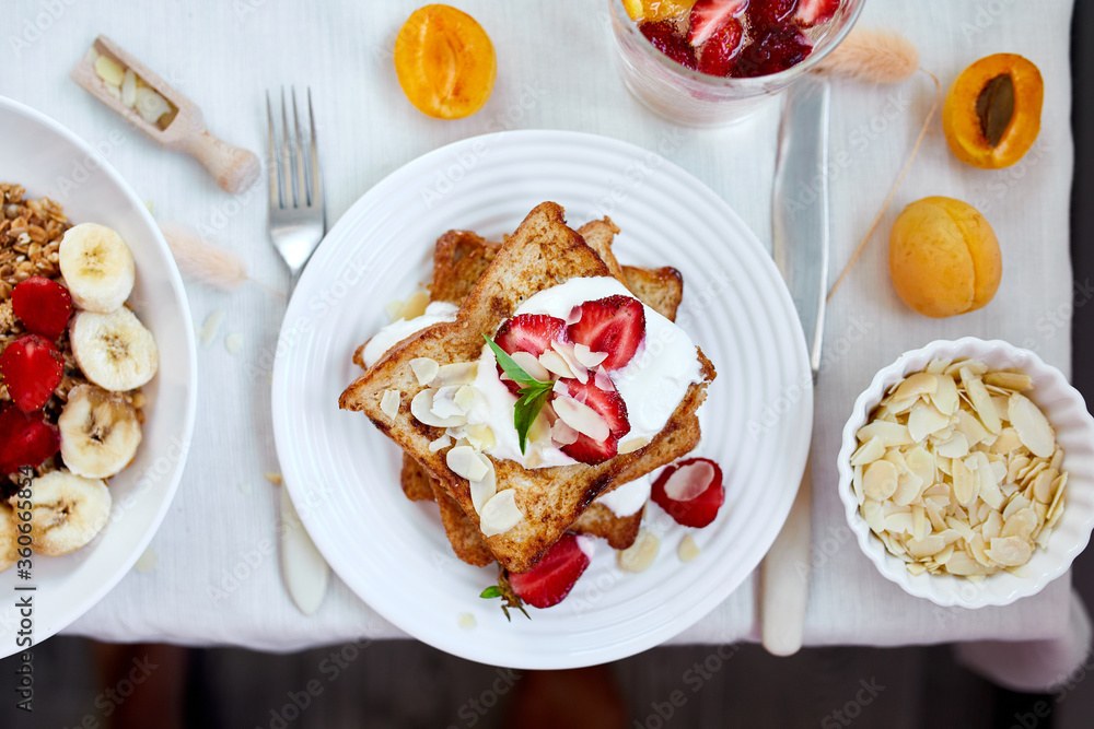 Fresh and bright continental breakfast table, abundance healthy meal variety crunch cereal, french toast, fruits, lemonade, coffee, croissant on table served, top view, flat lay, copy space, frame.. Fresh and bright continental breakfast table, abundance healthy meal variety crunch cereal, french toast, fruits, lemonade, coffee, croissant on table served, top view, flat lay, copy space, frame..