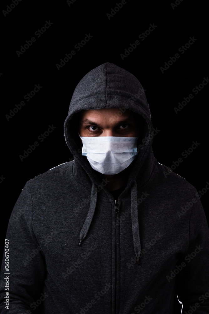 man in a medical mask on a black background, protection against coronavirus man in a medical mask on a black background, protection against coronavirus