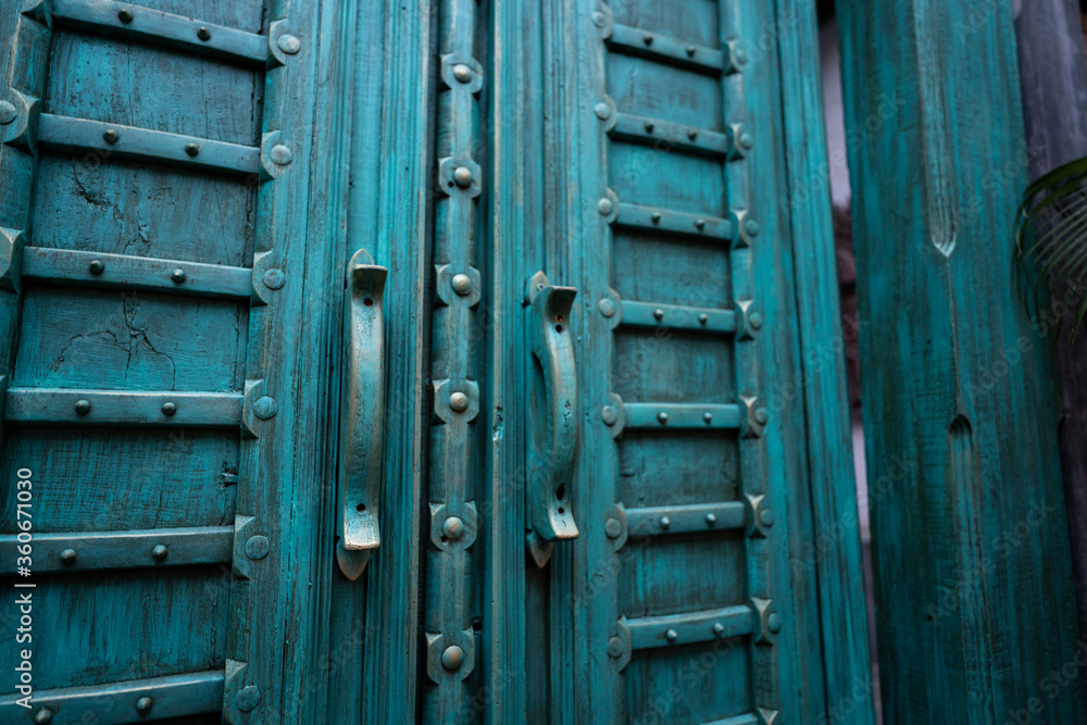 Close-up at an ancient wooden door with beautiful design in blue-turquoise color. House decoration object photo. Close-up at an ancient wooden door with beautiful design in blue-turquoise color. House decoration object photo.