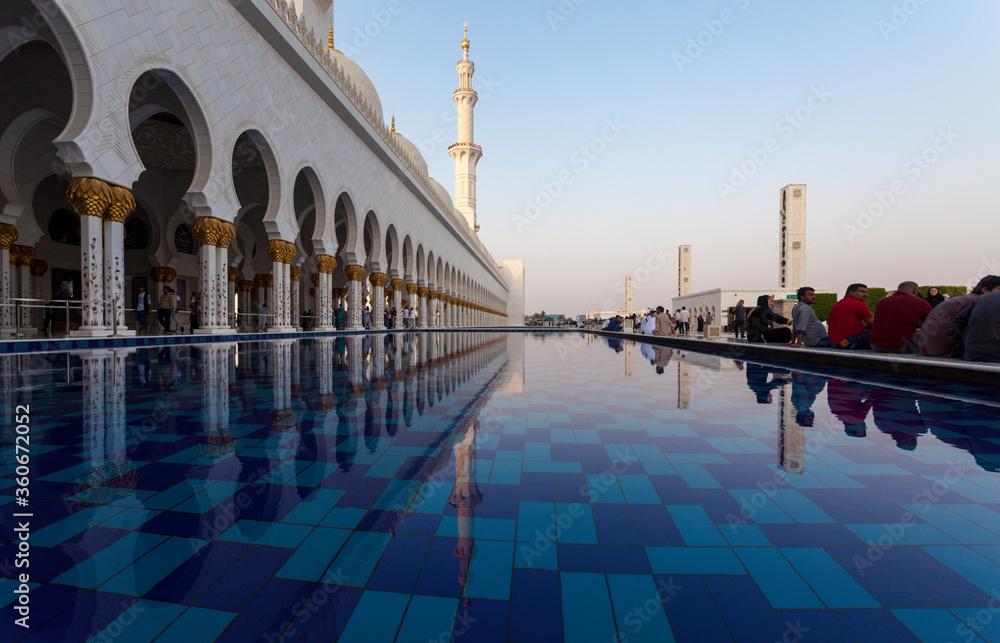Pool of the Grand Mosque, Abu Dhabi, UAE. People are sitting next to ...