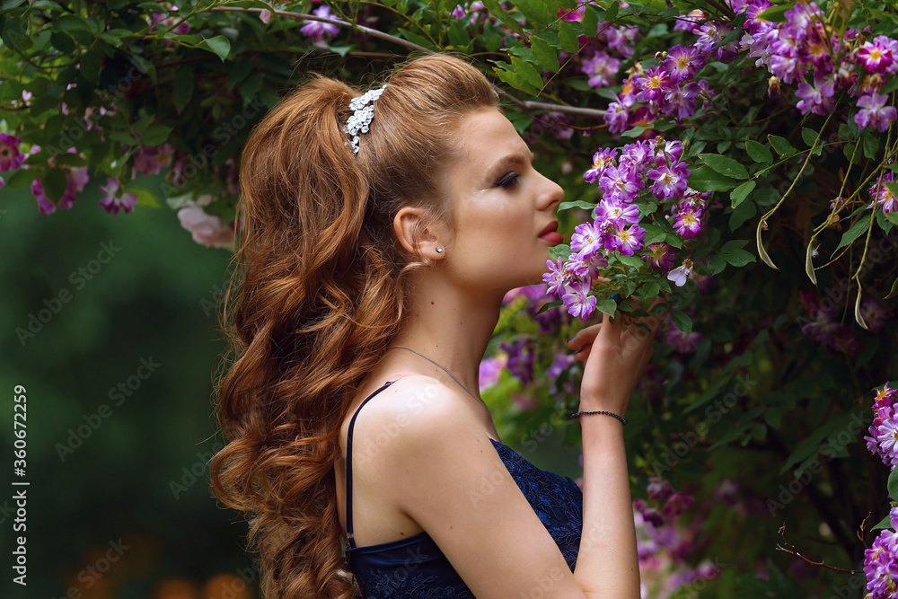 beautiful girl in a long evening dress in a beautiful garden with blooming roses beautiful girl in a long evening dress in a beautiful garden with blooming roses