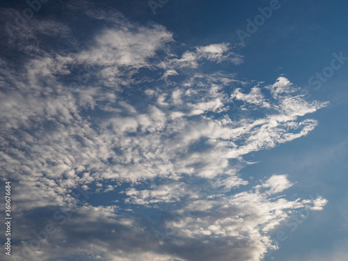 White sparse clouds in a blue sky.