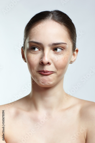 Headshot of emotional female face portrait with mocking facial expression.