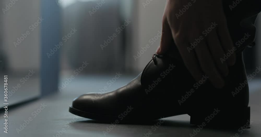 Slow motion man lace up his brown leather chukka boots indoor Slow motion man lace up his brown leather chukka boots indoor