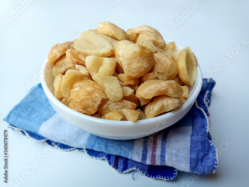 Aleurites moluccanus or Indonesian Candlenuts called Kemiri, inside a bowl, isolated in white background