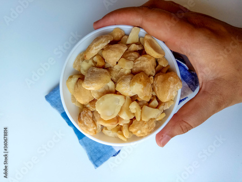 Aleurites moluccanus or Indonesian Candlenuts called Kemiri, inside a bowl, isolated in white background photo