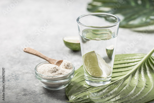 Collagen Powder and glass of water with  slice of Lime; Vitamin C . Collagen supplements may improve skin health by reducing wrinkles and dryness. photo