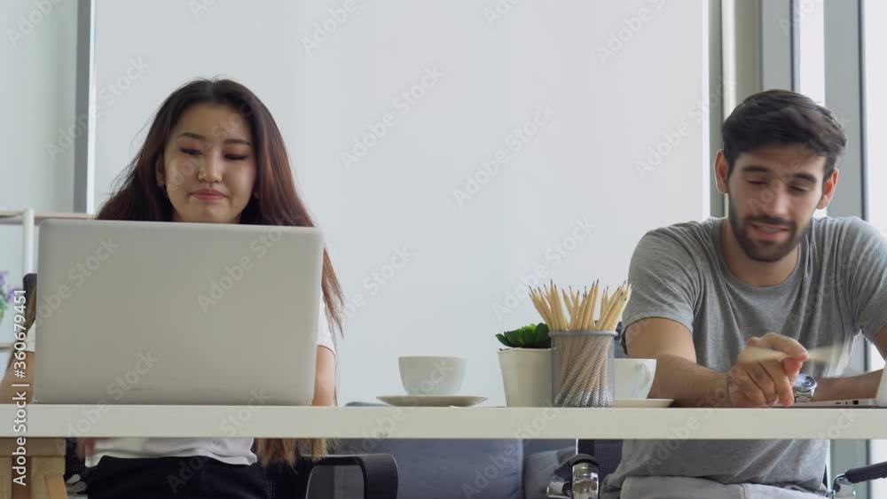young asian woman and caucasian man drinking coffee and using using computer to work from home. couple together and family relationship concept young asian woman and caucasian man drinking coffee and using using computer to work from home. couple together and family relationship concept