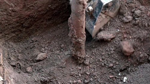 Wallpaper Mural Excavator digs brown clay and sandy soil.Arrangement of a water well.Close-up. Torontodigital.ca