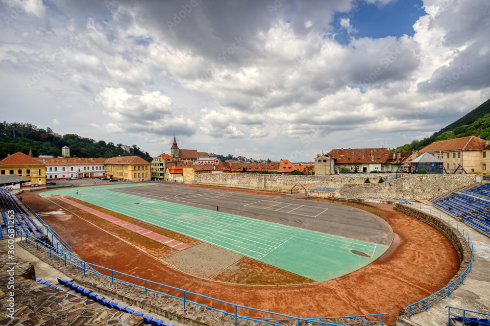BRASOV, ROMANIA - Circa 2020: empty sport stadium and running track with moody cloudy sky. Concept of outdoor activities. No outdoor activity due to lock down.