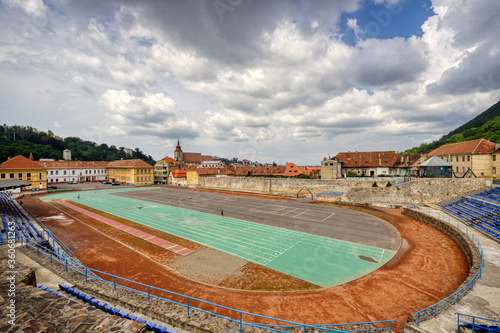 BRASOV, ROMANIA - Circa 2020: empty sport stadium and running track with moody cloudy sky. Concept of outdoor activities. No outdoor activity due to lock down.