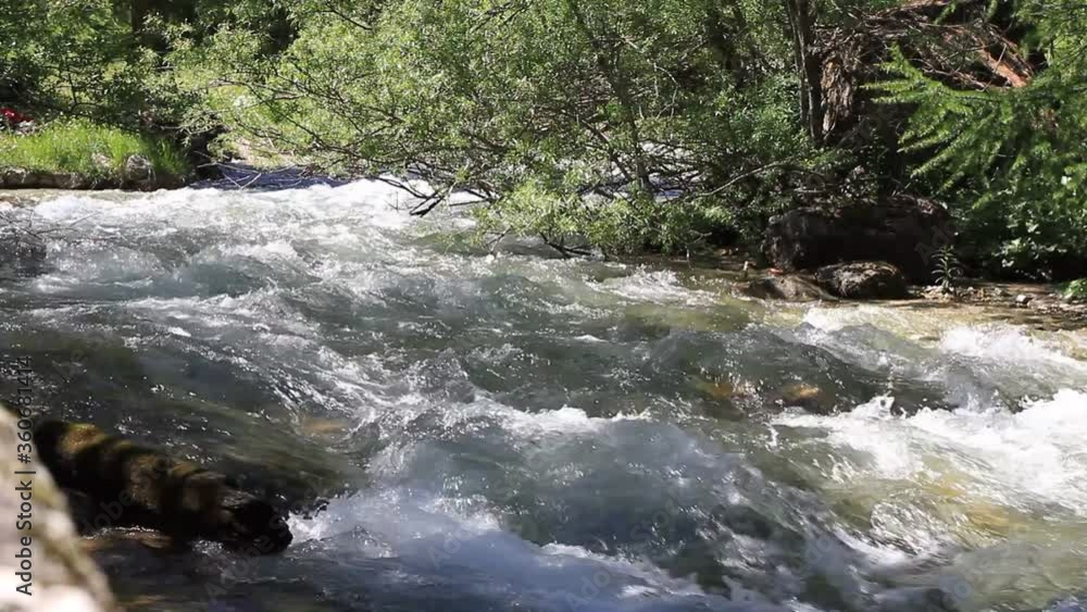 Waterfalls on a mountain river. Mountain river with abundant clear stream. Babbling creek with stone boulders flowing. Swift splashing water. Waterfalls on a mountain river. Mountain river with abundant clear stream. Babbling creek with stone boulders flowing. Swift splashing water.