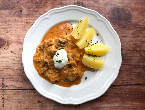 Hungarian Szegedin or Szeged Goulash with sour cabbage and boiled potatoes. Meat in which is cut into cubes, sour cream, onions, garlic, paprika and laurel are the ingredients.
