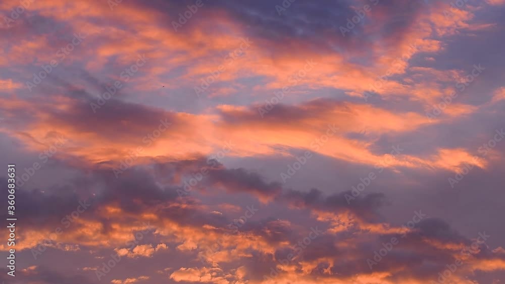 Clouds colored by the setting sun move through the evening sky close up Clouds colored by the setting sun move through the evening sky close up