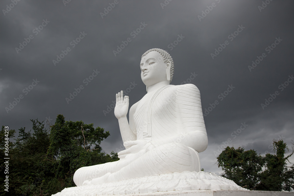 Mihintale, Sri Lanka - CIRCA 2018: Big white Buddha statue against blue sky in Mihintale, the cradle of buddhism at Sri Lanka Mihintale, Sri Lanka - CIRCA 2018: Big white Buddha statue against blue sky in Mihintale, the cradle of buddhism at Sri Lanka