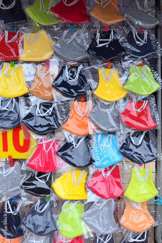 Many face masks of various colors are packed in clear plastic bags on the stall.