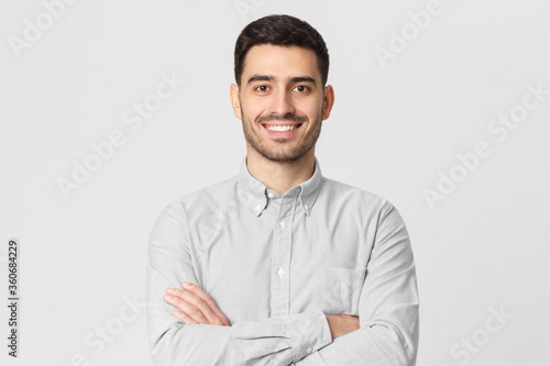 Smiling businessman in gray shirt isolated on studio background © Damir Khabirov
