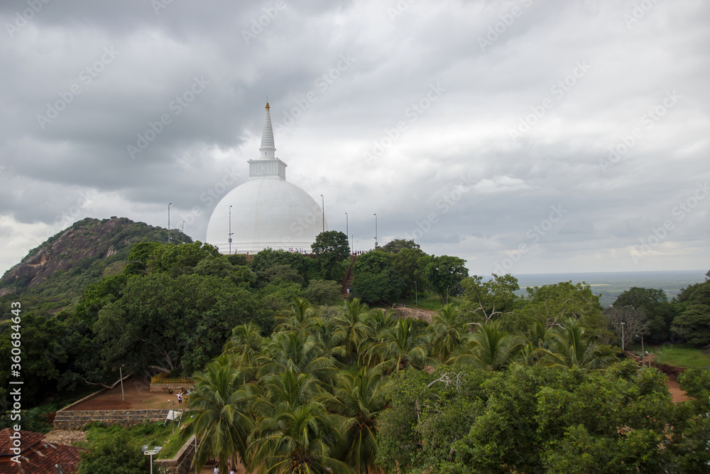 Fototapeta premium Mihintale, Sri Lanka - CIRCA 2018: Big white Buddha statue against blue sky in Mihintale, the cradle of buddhism at Sri Lanka