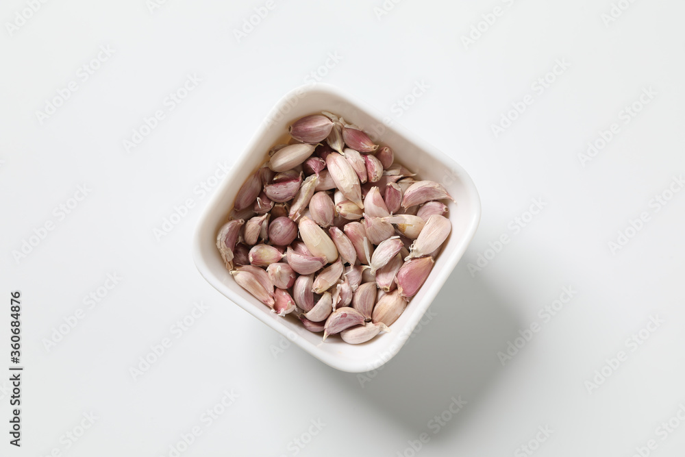 Garlic cloves in the peel against part of garlic head isolated on white background Garlic cloves in the peel against part of garlic head isolated on white background