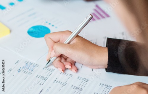 Hand of business woman pointing document data graph and chart with pen, marketing and investment, report of statistics profit for financial, economic and growth of finance, management and planning.