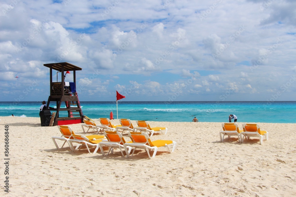 Φωτογραφία Dream holiday / vacation - The view on the empty white sandy beach and Caribbean turquoise sea with lifeguard tower,  yellow sun beds and parasols / umbrellas in Cancun, Mexico