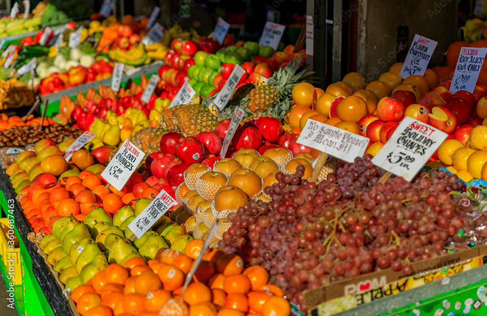 Fresh fruits like apples, pears, grapes and oranges for sale at a stall at Pike Place Market in Seattle, Washington