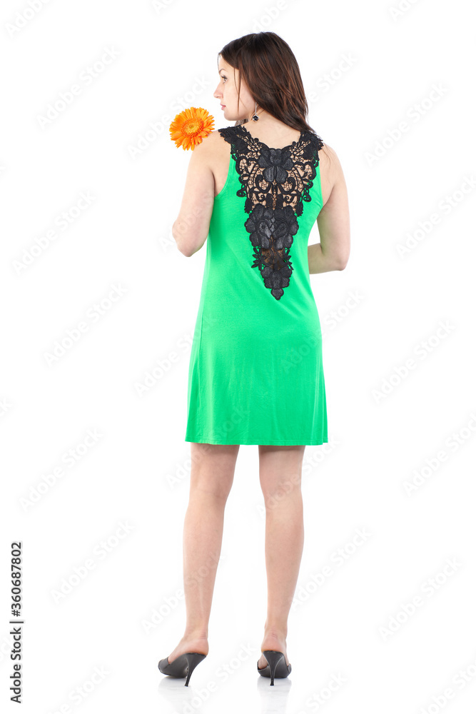 Back view portrait of a young beautiful woman in green summer dress. Woman with gerbera flower Back view portrait of a young beautiful woman in green summer dress. Woman with gerbera flower