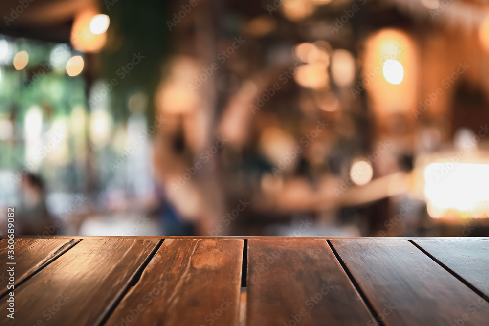 Wooden table on a restaurant blurred background is an abstract background.