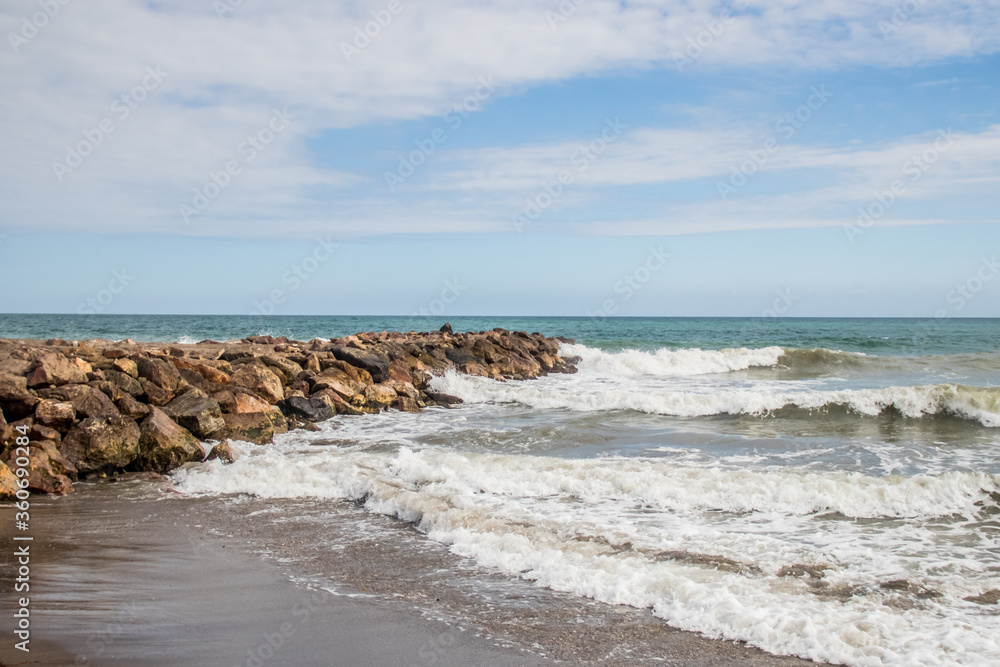 Rocks in front of the sea. Beach of rocks and the sea in Vera Playa, Andalusia, Spain Rocks in front of the sea. Beach of rocks and the sea in Vera Playa, Andalusia, Spain