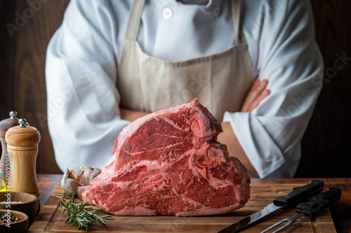 thick cutted t-bone steak with butcher man photo